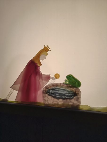 Schattentheater - Szene aus "Der Froschkönig" von Lys Soleil: Die Prinzessin am Brunnen mit der goldenen Kugel und dem Frosch